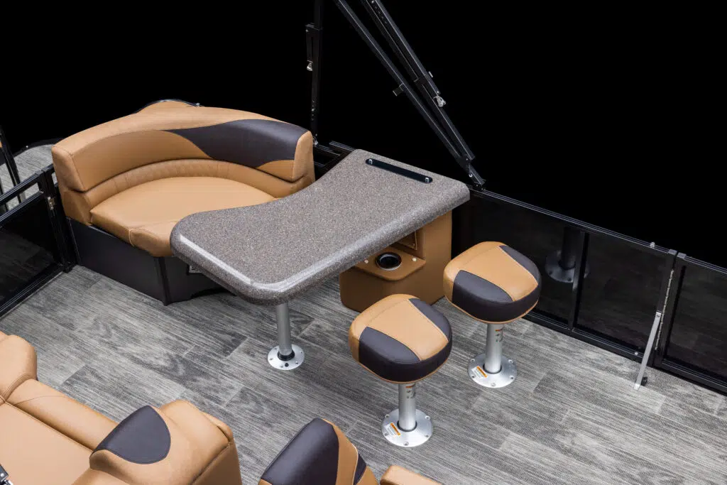 The image shows the interior of a LSZ Entertainer with a granite-like table and brown cushioned seating. The setup includes a curved bench, three stools, and wood-like flooring, all in a color scheme of brown and black. The area appears clean and is well-appointed.