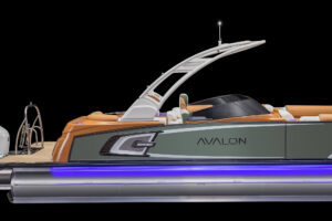 A sleek Avalon pontoon boat with a modern design, featuring a white and green color scheme. The boat has comfortable seating, an arch for attaching a canopy, and is highlighted with blue LED lighting under the pontoon. The brand name "Avalon" is prominently displayed.