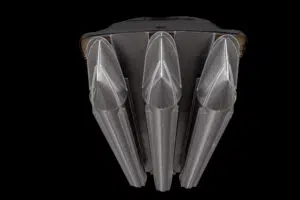 The image shows the underside of a black and metallic vehicle, featuring three large, aerodynamic, fin-like structures arranged in parallel against a black background.