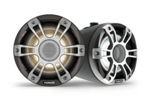 Two Fusion brand marine speakers. The left speaker features a golden-brown cone with a black and silver grille design. The right speaker has a silver cone and an all-silver grille design. Both speakers display the Fusion logo at the bottom of the grille.