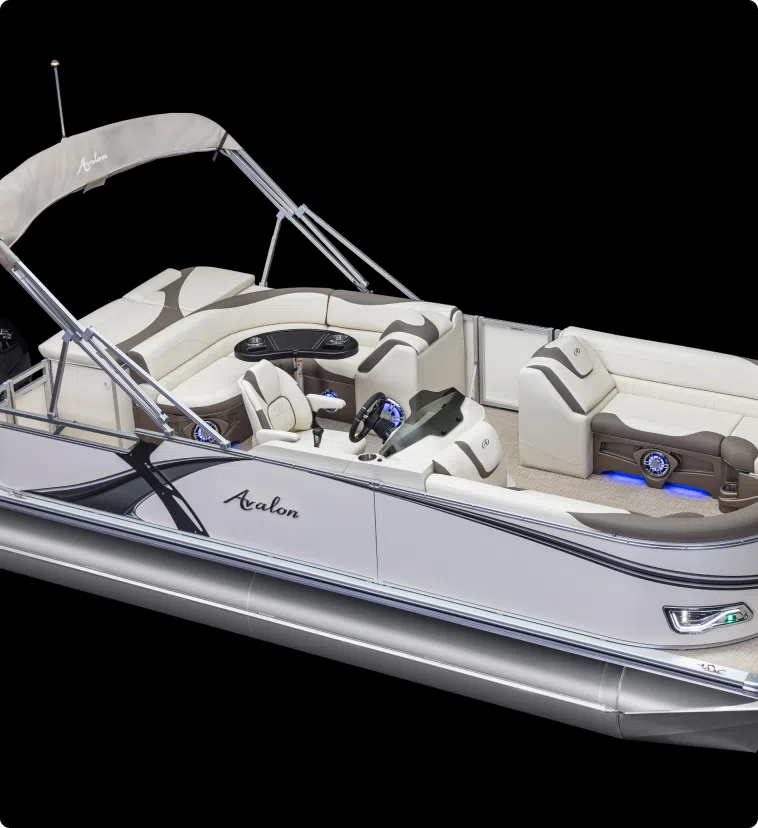 Experience the epitome of luxury with our new pontoon boat sales. The Avalon pontoon boat boasts beige and gray seating, a sleek design, and a Bimini top. Inside, find plush cushions, a modern control panel, and blue LED lights illuminating the space—all set against a striking black background.