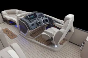 Interior view of a modern boat cockpit, featuring a central steering wheel, digital displays, and beige cushioned seats. The flooring is wooden, and the space is well-lit with blue ambient lighting. The focus is on the sleek design and navigation area.