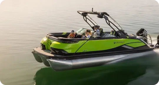 A bright green pontoon boat with a sleek design from top pontoon boat brands glides over calm water. Three people on board are wearing life jackets, enjoying a sunny day. The boat has a sporty look with black accents and a canopy.