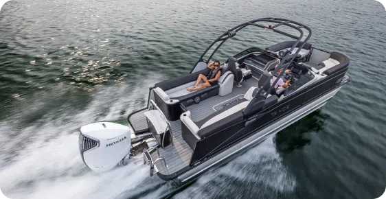 A lively group of friends relaxes on a sleek pontoon, cruising the lake with one of the top pontoon boat brands, enjoying the sunshine and good company.