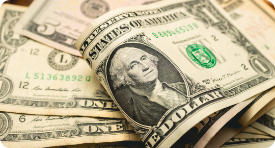 A close-up image of multiple U.S. dollar bills, with a prominent one-dollar bill featuring George Washington's portrait in the foreground, captures the intricate details much like pontoon boat brands showcase craftsmanship. The bills are in a slightly messy pile, revealing their detailed design and texture.