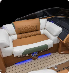 Luxurious boat seating with cream, brown, and green upholstery, featuring cushioned armrests and a diamond-patterned backrest. The seat shines with ambient blue lighting below and wooden accents surrounding the area—reflecting elegance that's worth exploring alongside competitive pontoon prices.